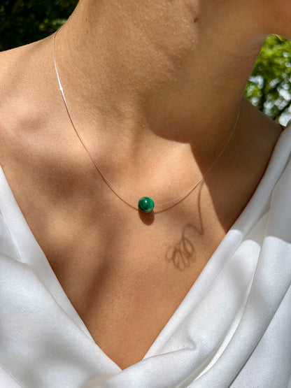 Collier EMY avec pierre de Malachite, porté sur un haut blanc.