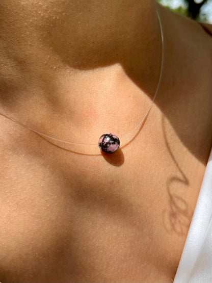 Collier EMY avec pierre de Rhodonite, porté sur un haut blanc.