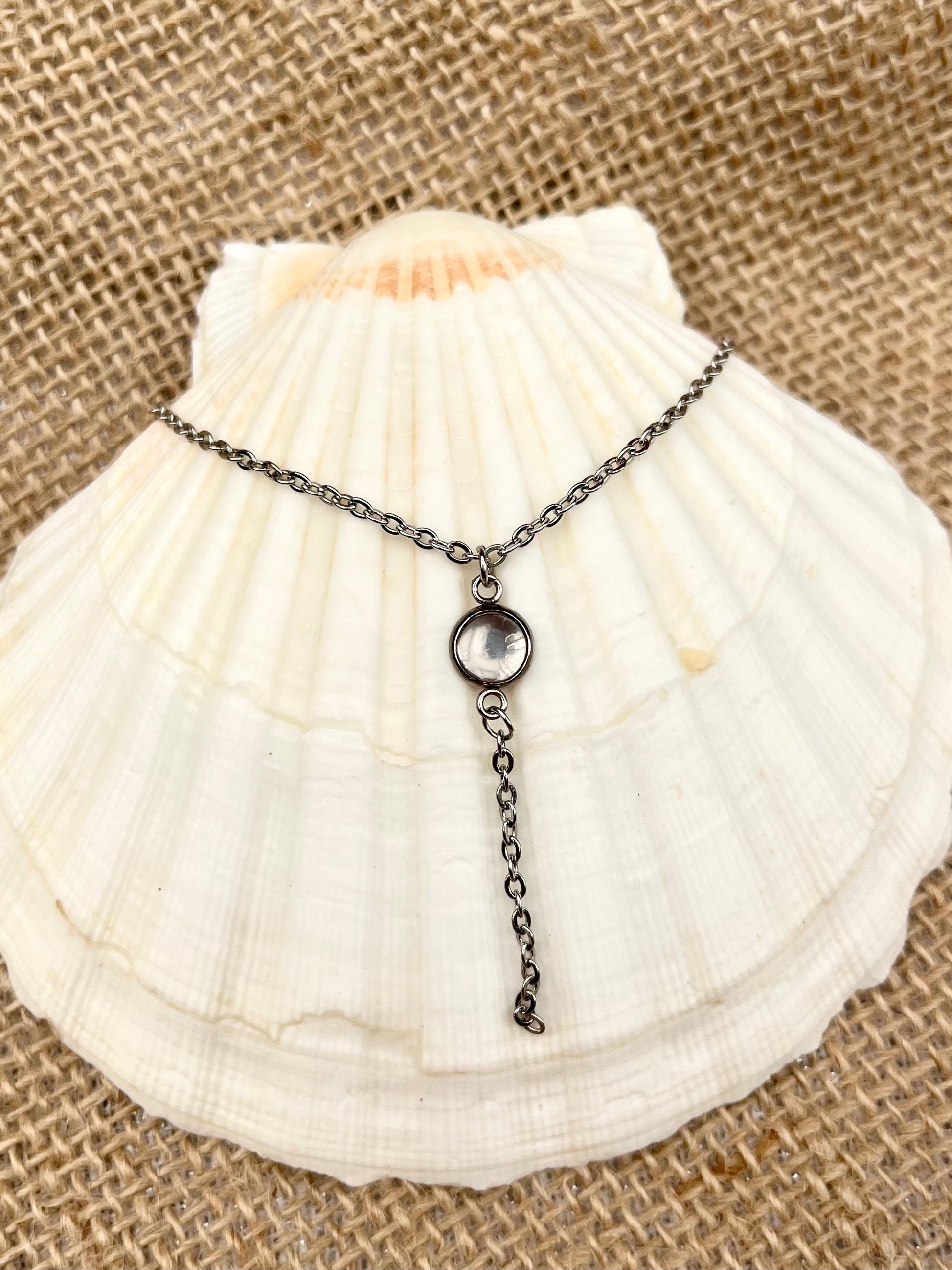 Collier LÉA, avec pierre de Quartz Rose, exposé sur un coquillage.