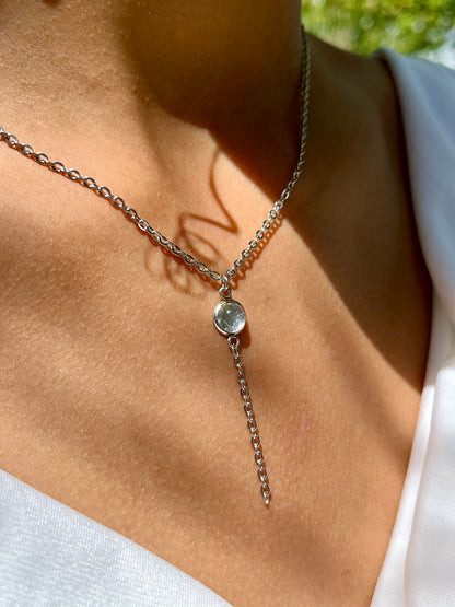 Collier LÉA, en acier inoxydable argent et pierre de Quartz Rose, porté par une femme sur un haut blanc.