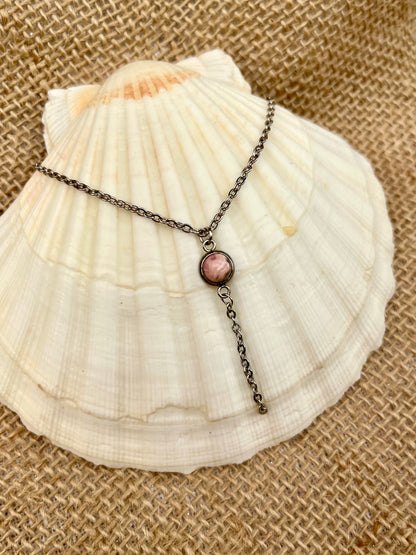 Collier LÉA, avec pierre de Rhodochrosite, exposé sur un coquillage.