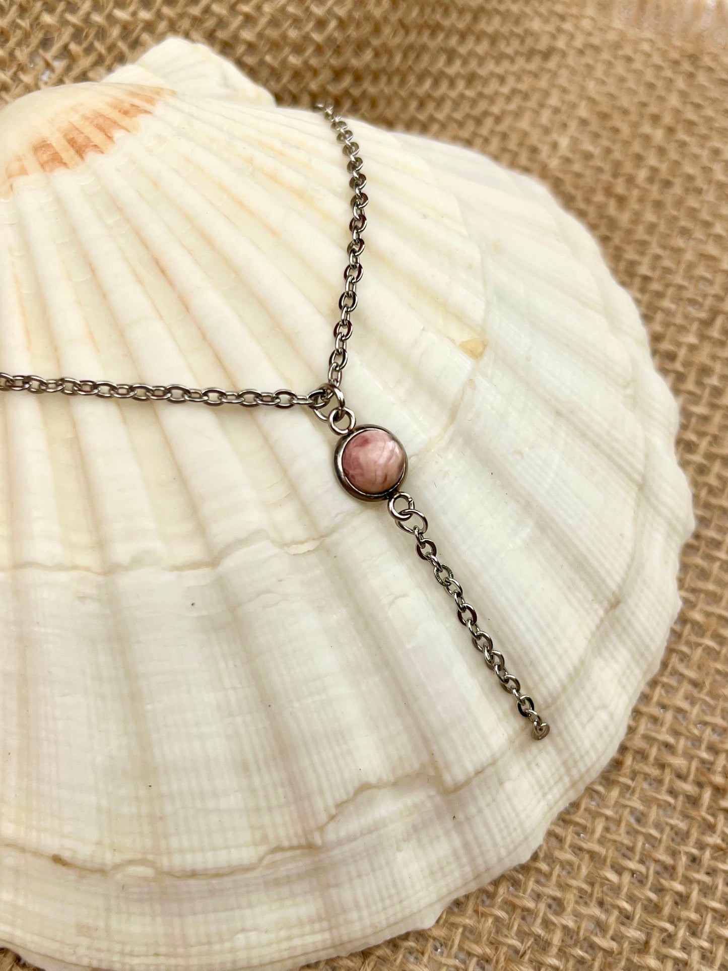 Collier LÉA, avec pierre de Rhodochrosite, exposé sur un coquillage.