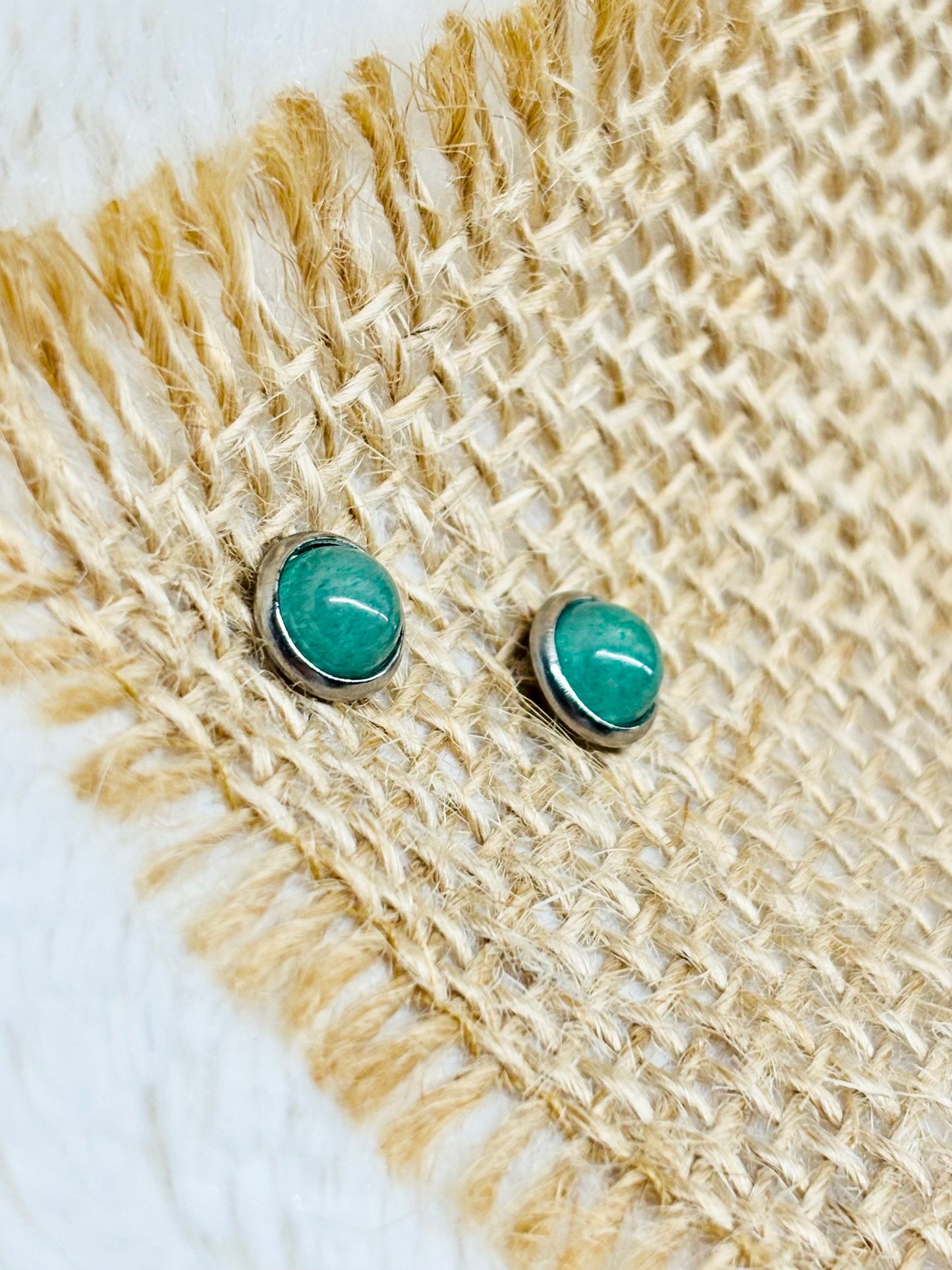 Boucles d'oreille LISE, avec pierre d'Aventurine, exposées sur de la toile de jute.