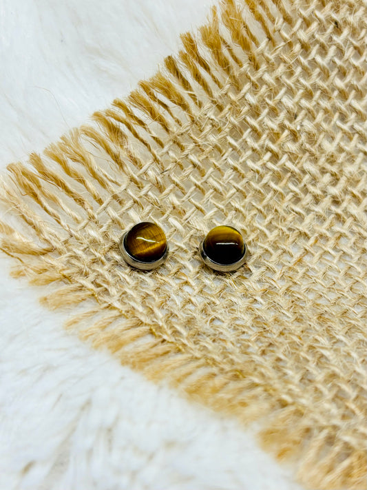 Boucles d'oreille LISE, avec pierre d'oeil de Tigre, exposées sur un fond en toile de jute.