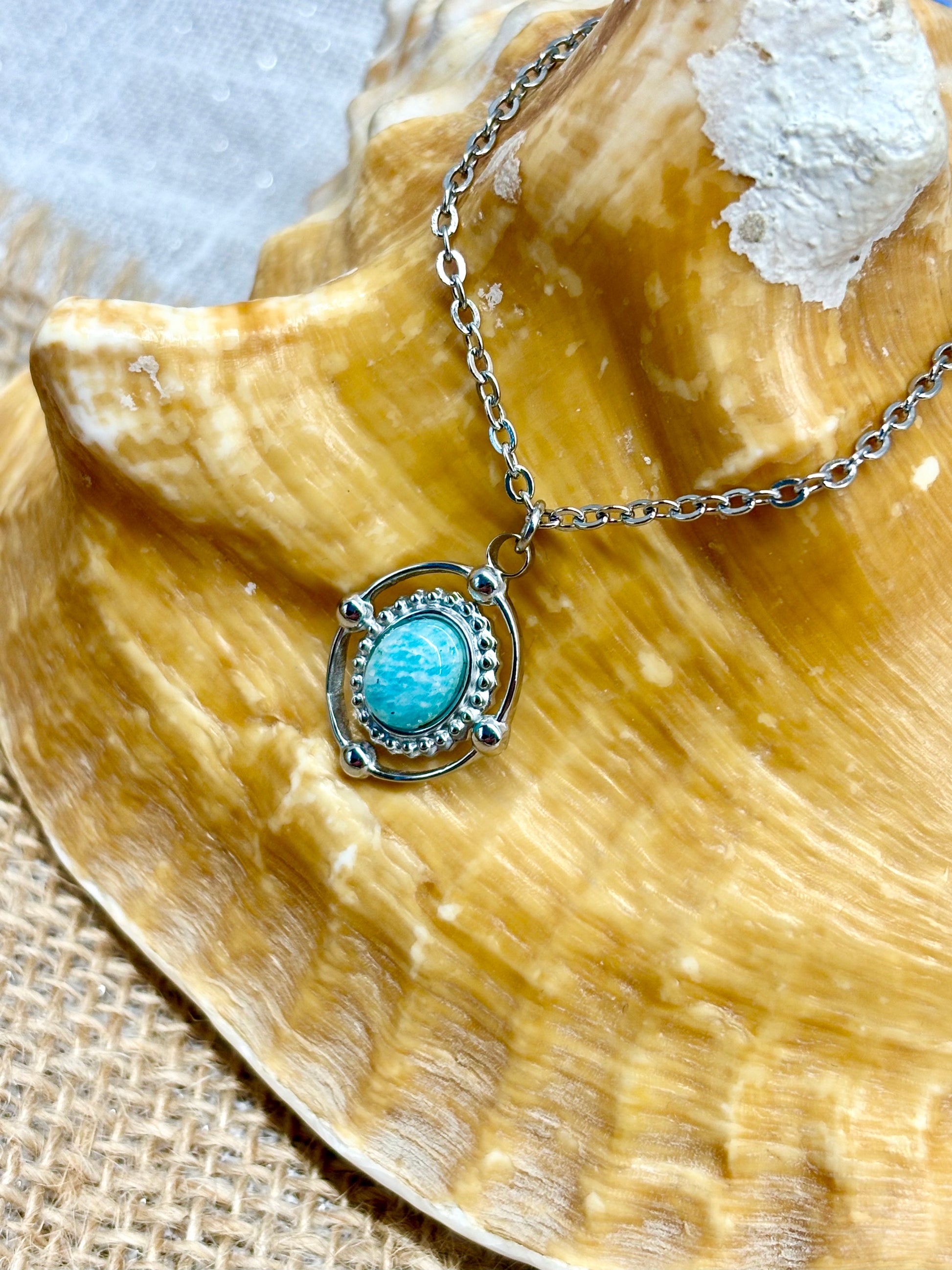 Collier LOUISA, avec pierre d'Amazonite, exposé sur un coquillage.