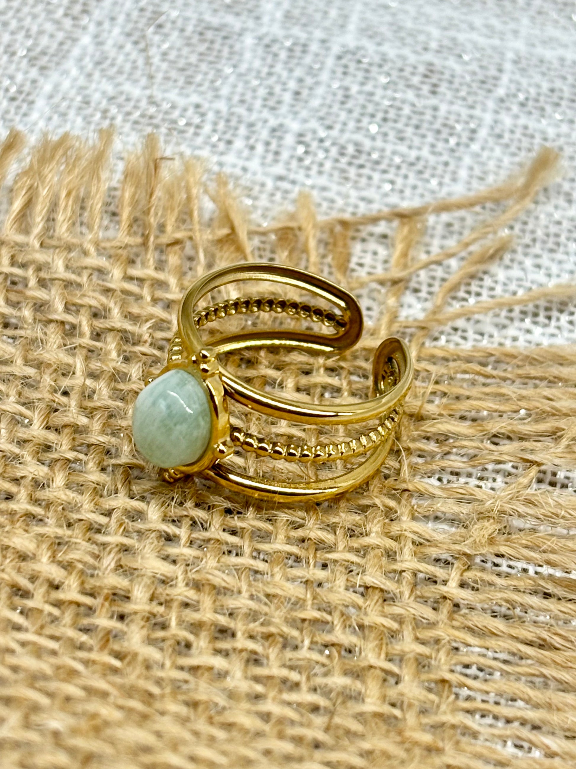 Bague LOUISON, avec pierre d'Amazonite, exposée sur un fond en toile de jute.