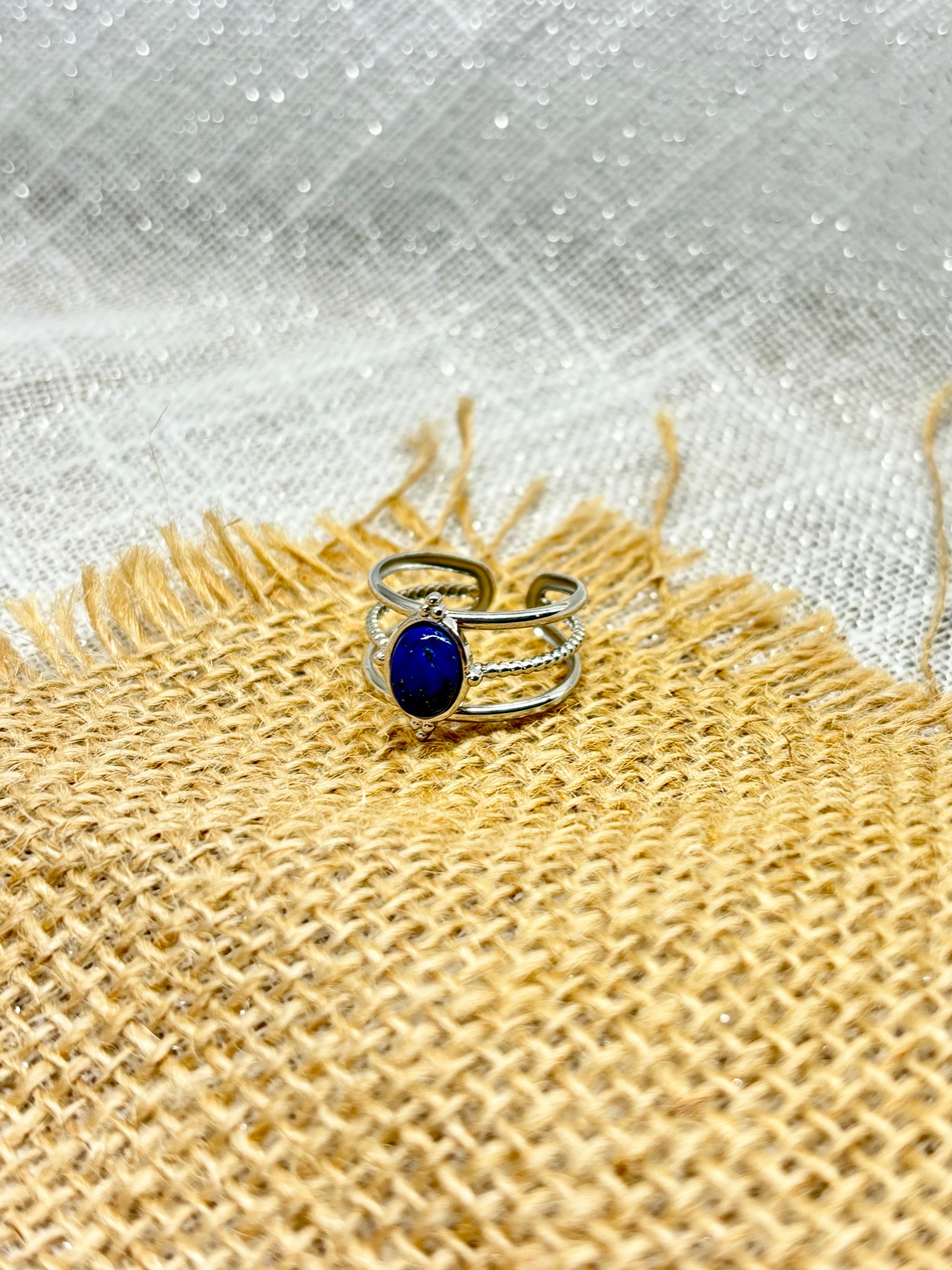 Bague LOUISON, avec pierre de Lapis-Lazuli, exposée sur un fond en toile de jute.