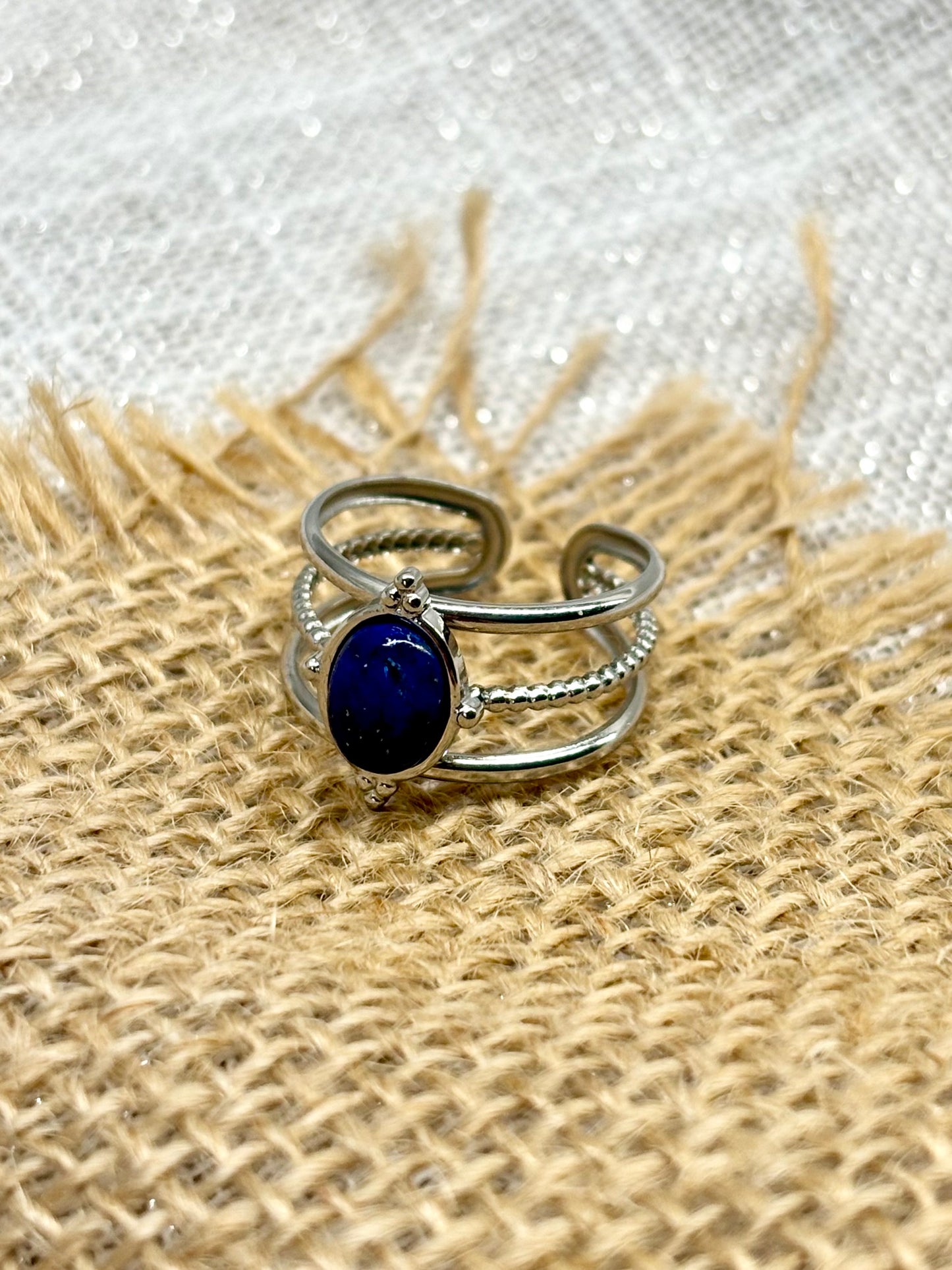 Bague LOUISON, avec pierre de Lapis-Lazuli, exposée sur un fond en toile de jute.