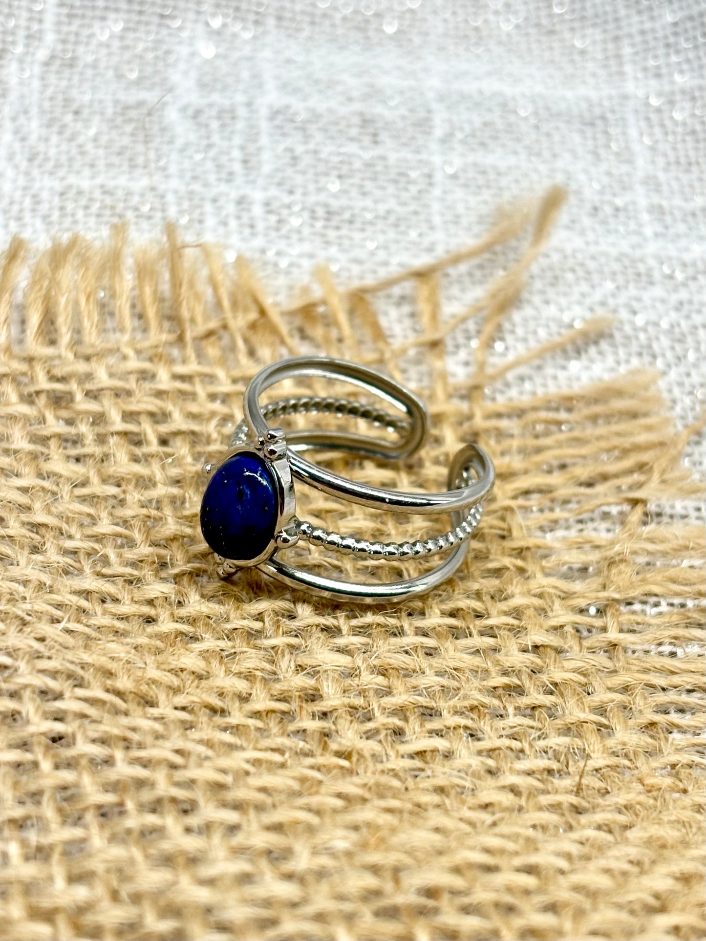 Bague LOUISON, avec pierre de Lapis-Lazuli, exposée sur un fond en toile de jute.