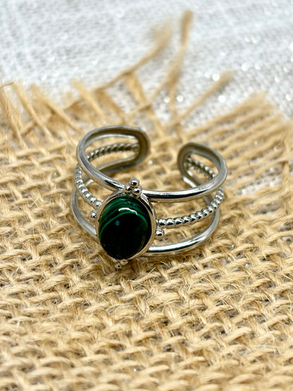 Bague LOUISON, avec pierre de Malachite, exposée sur de la toile de jute.