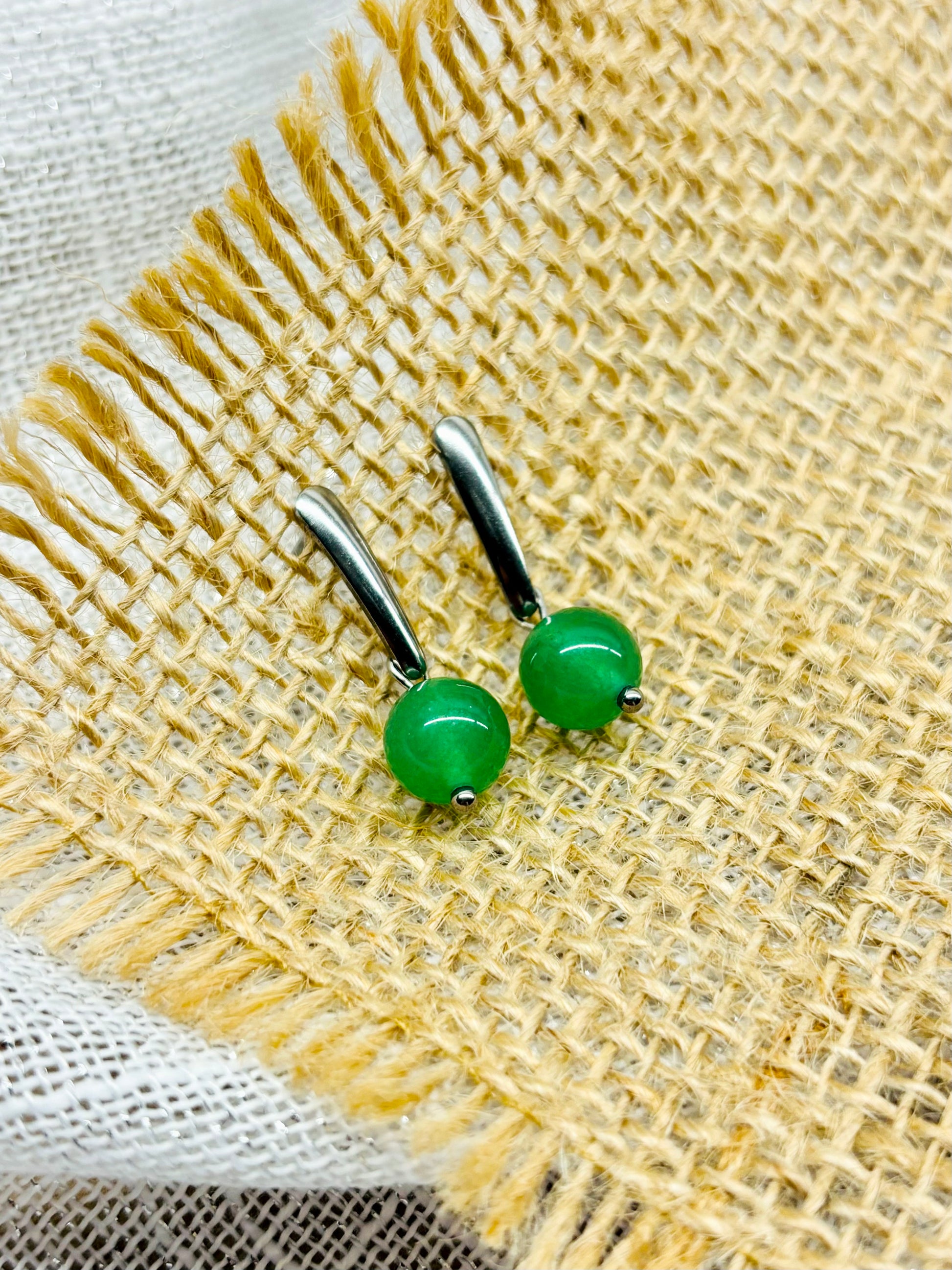 Boucles d'oreille MADELEINE, avec pierre d'Aventurine, exposées sur de la toile de jute.