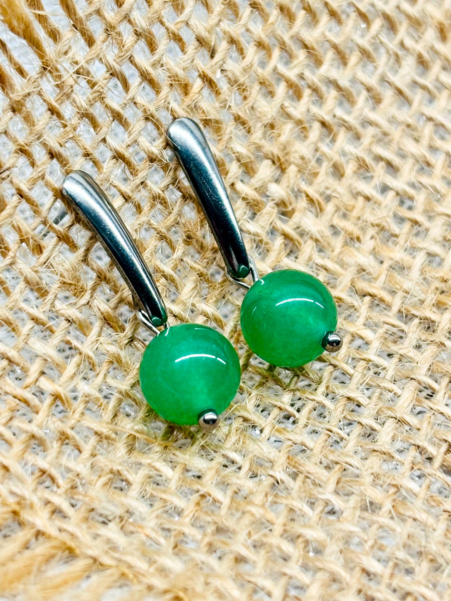 Boucles d'oreille MADELEINE, avec pierre d'Aventurine, exposées sur de la toile de jute.