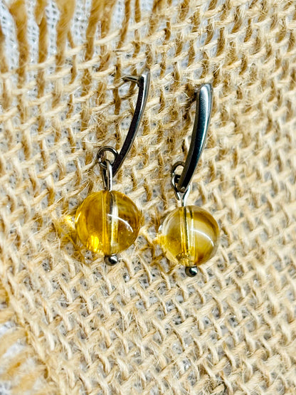 Boucles d'oreille MADELEINE, avec pierre de Citrine, exposées sur de la toile de jute..