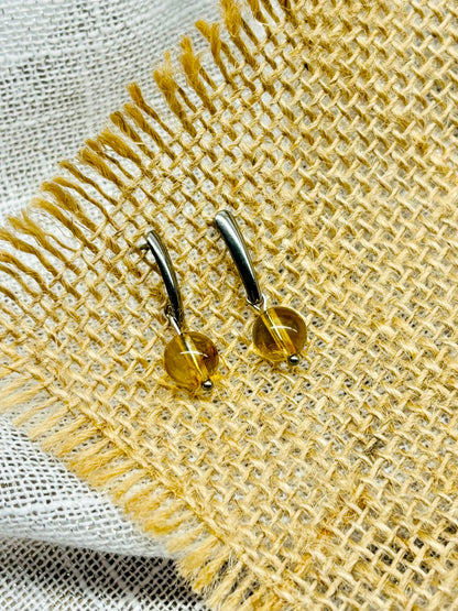 Boucles d'oreille MADELEINE, avec pierre de Citrine, exposées sur de la toile de jute..