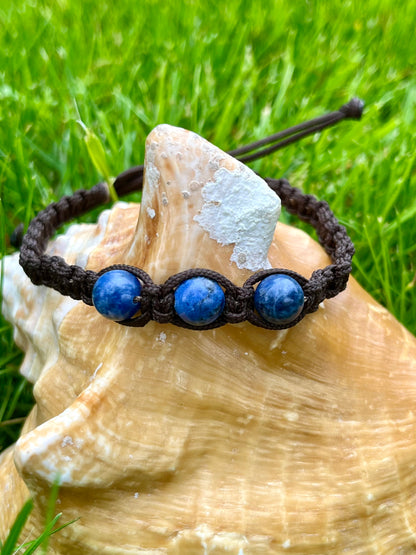 Bracelet MAËL, avec pierres de Sodalite, exposé sur un coquillage.