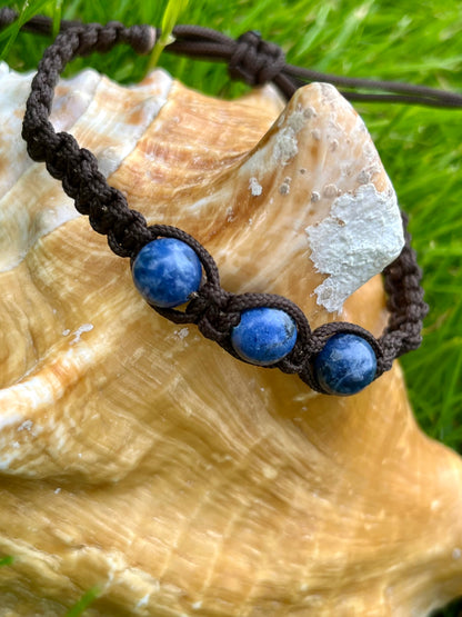 Bracelet MAËL, avec pierres de Sodalite, exposé sur un coquillage.