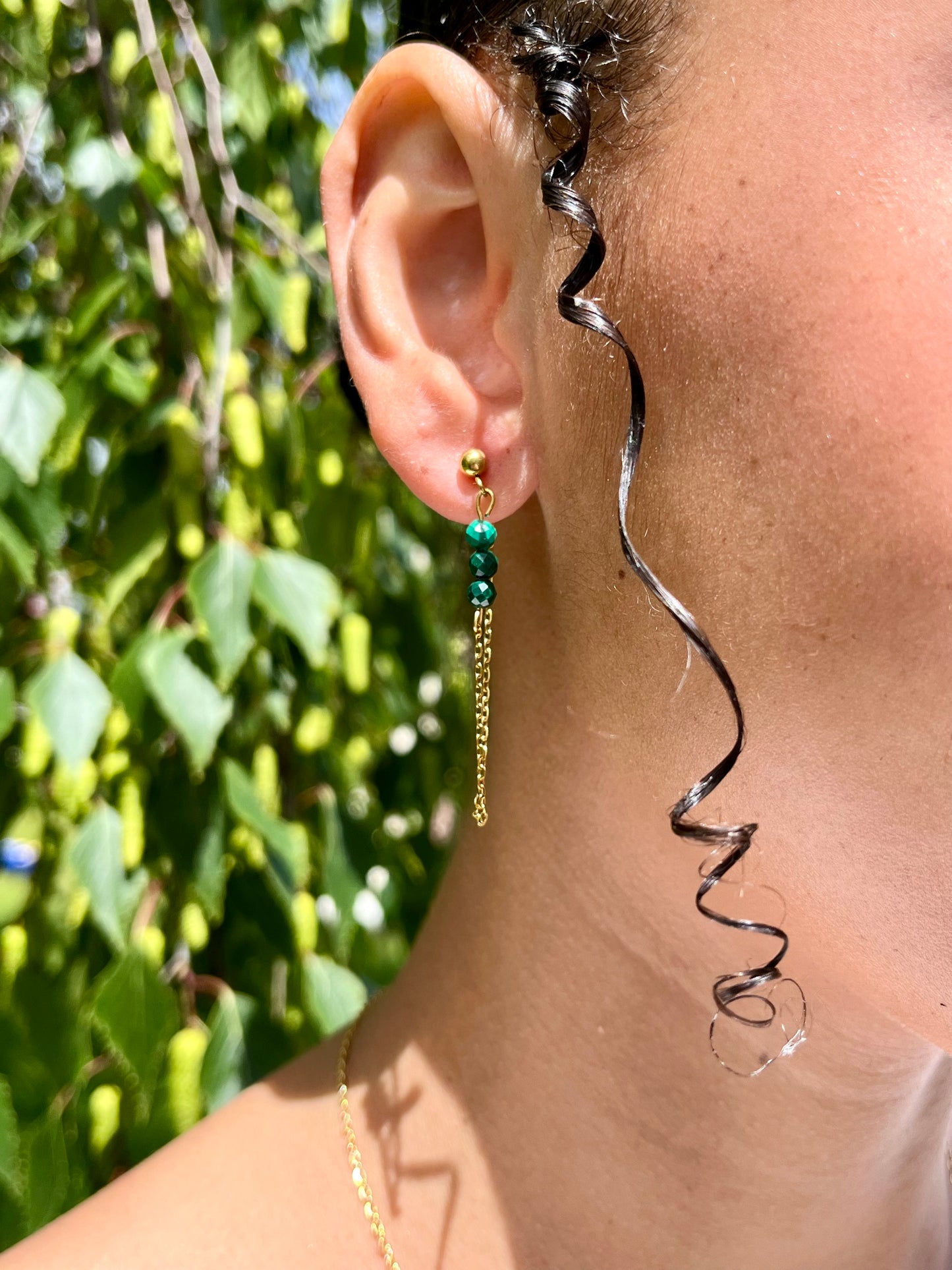 Boucles d'Oreille MALIA, de couleur dorée avec pierres de Malachite, portées.