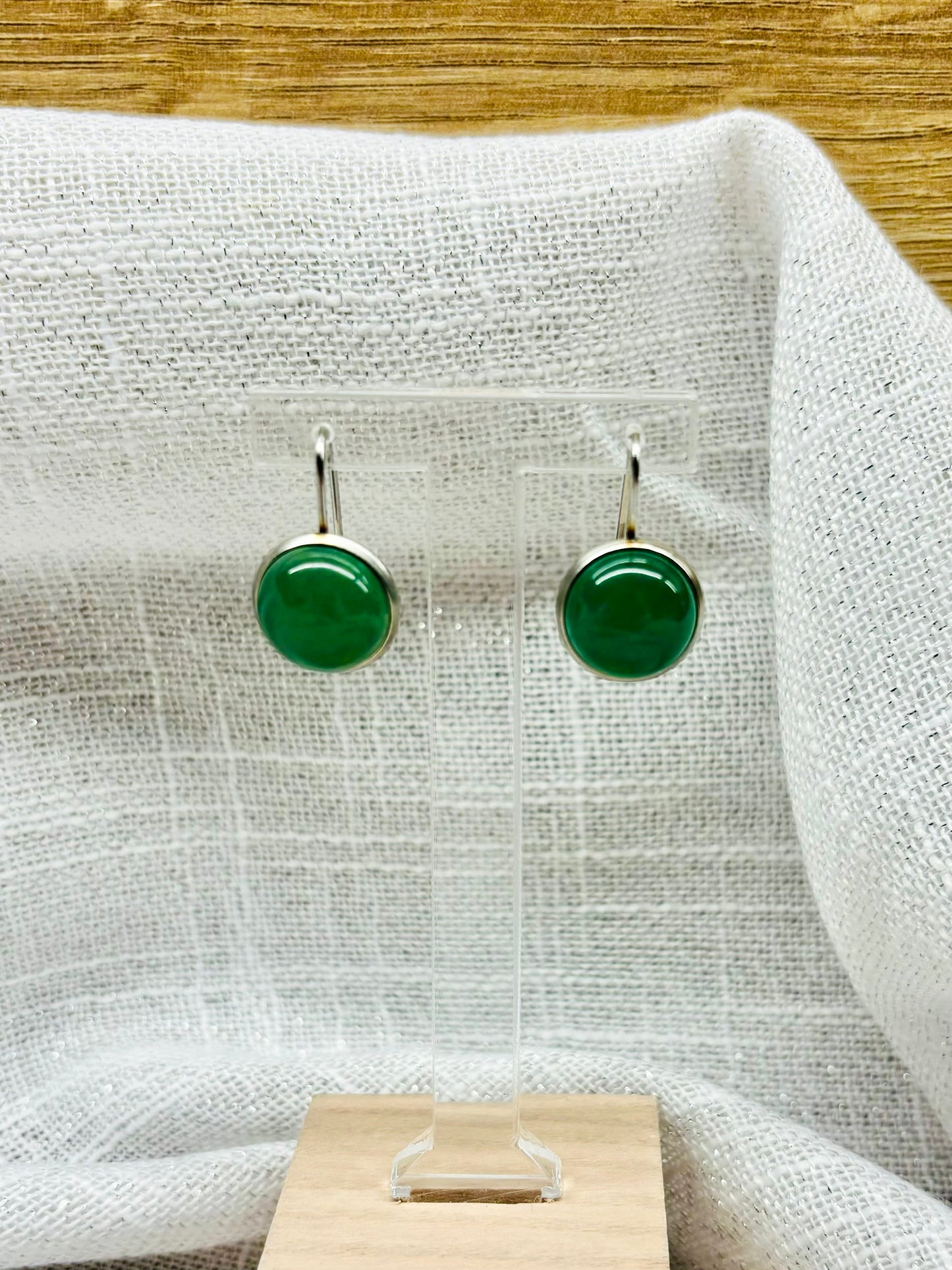 Boucles d'oreille THÉANA, avec pierre d'Aventurine, exposées sur un fond en lin.