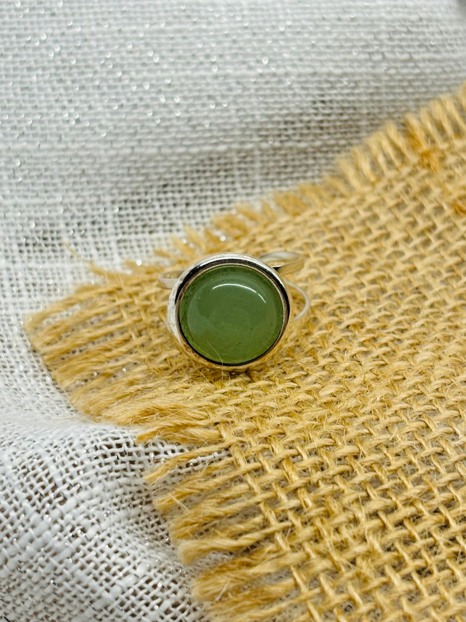 Bague THÉA, en argent et pierre d'Aventurine, sur un fond de lin et toile de jute.