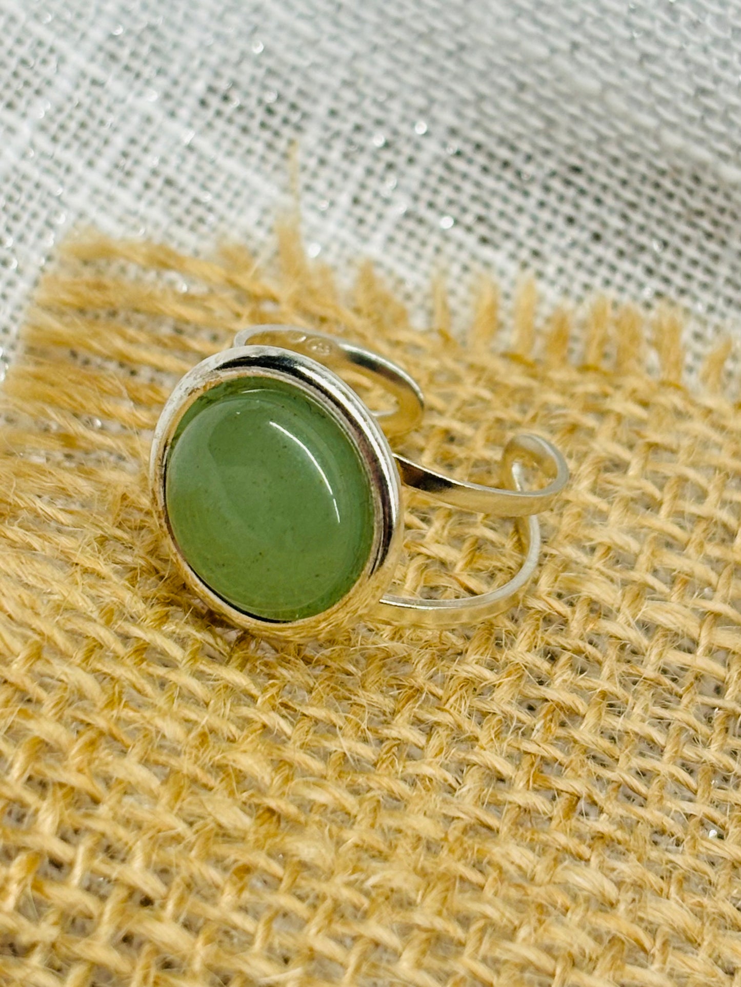 Bague THÉA, en argent et pierre d'Aventurine, sur un fond de lin et toile de jute.