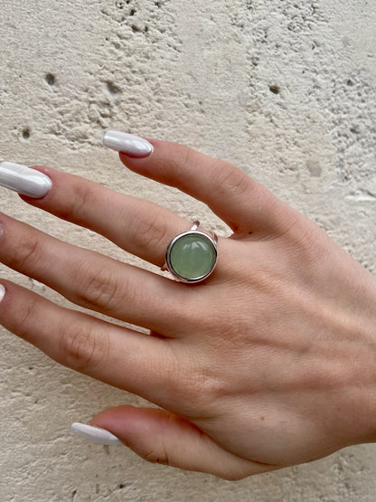 Bague THÉA, en argent et pierre d'Aventurine, portée sur une main de femme.