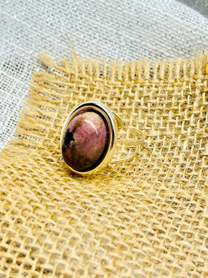 Bague THÉA, en argent et pierre de Rhodonite, sur un fond en lin et toile de jute.