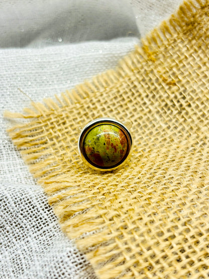 Bague THÉA, en argent et pierre d'Unakite, sur un fond en lin et toile de jute.