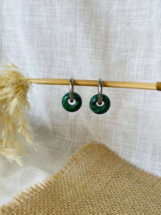 Boucles d'oreille THELMA, avec pierre de Malachite, exposées sur un fond en lin.