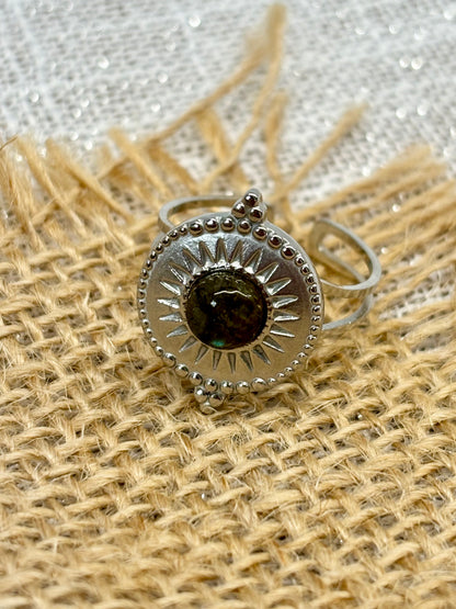 Bague ZÉLIE en acier inoxydable argent, avec pierre de Labradorite, exposé sur de la toile de jute et fond en lin blanc.