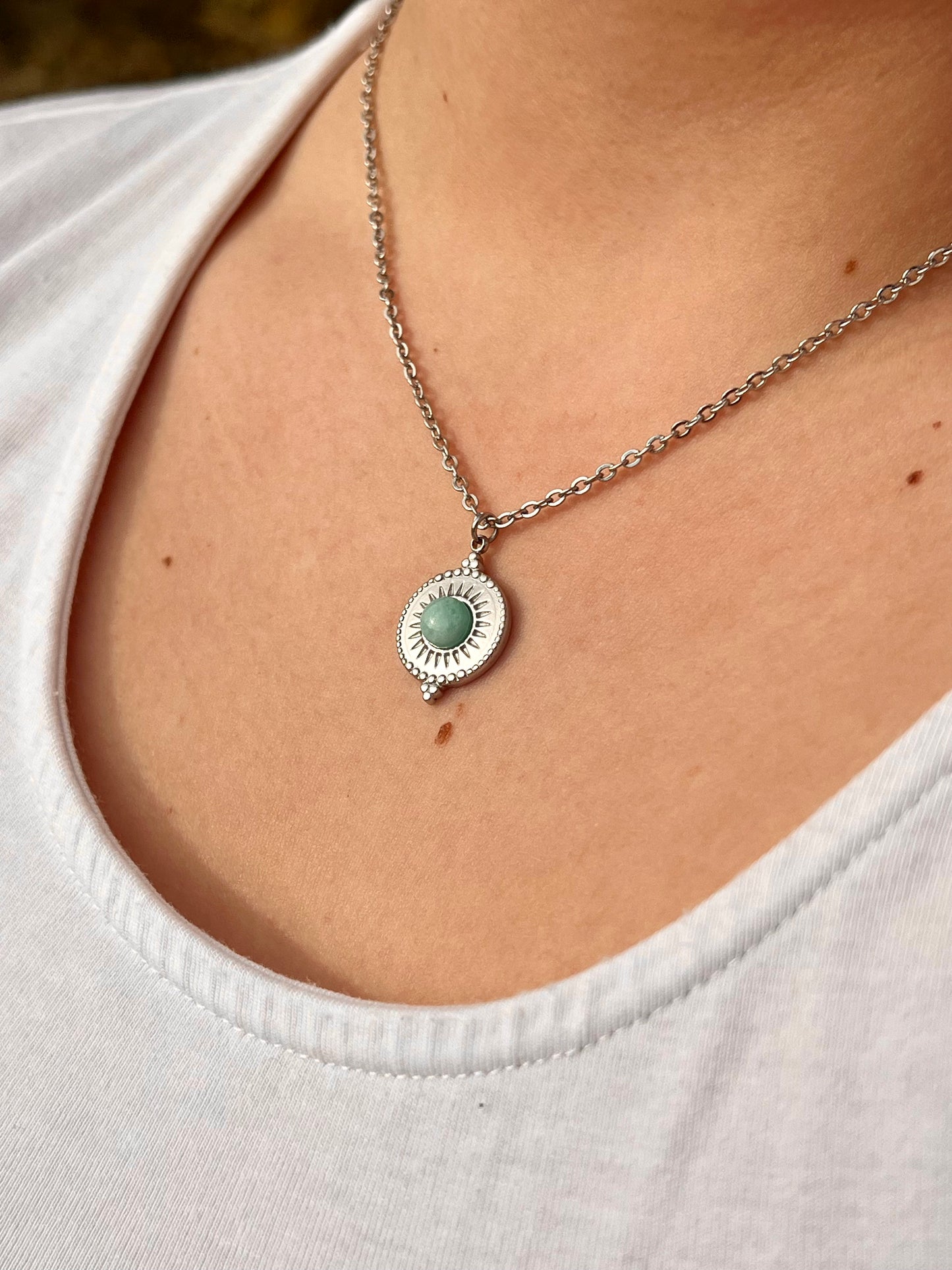 Collier ZÉLIE en acier inoxydable argent, avec pierre d'Amazonite, porté par une femme dans les rochers..